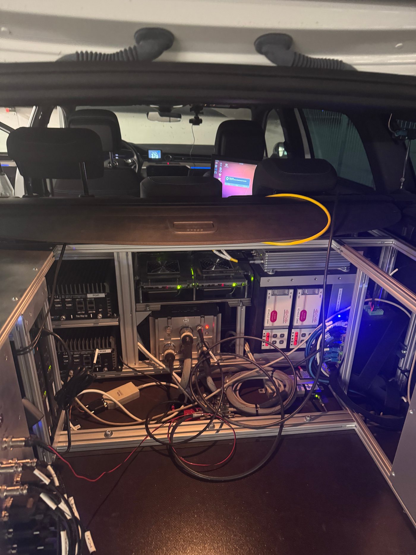 The rear compute rack inside Fortuna, exposed with its PCs, GPUs, and batteries during the 2023 recovery work